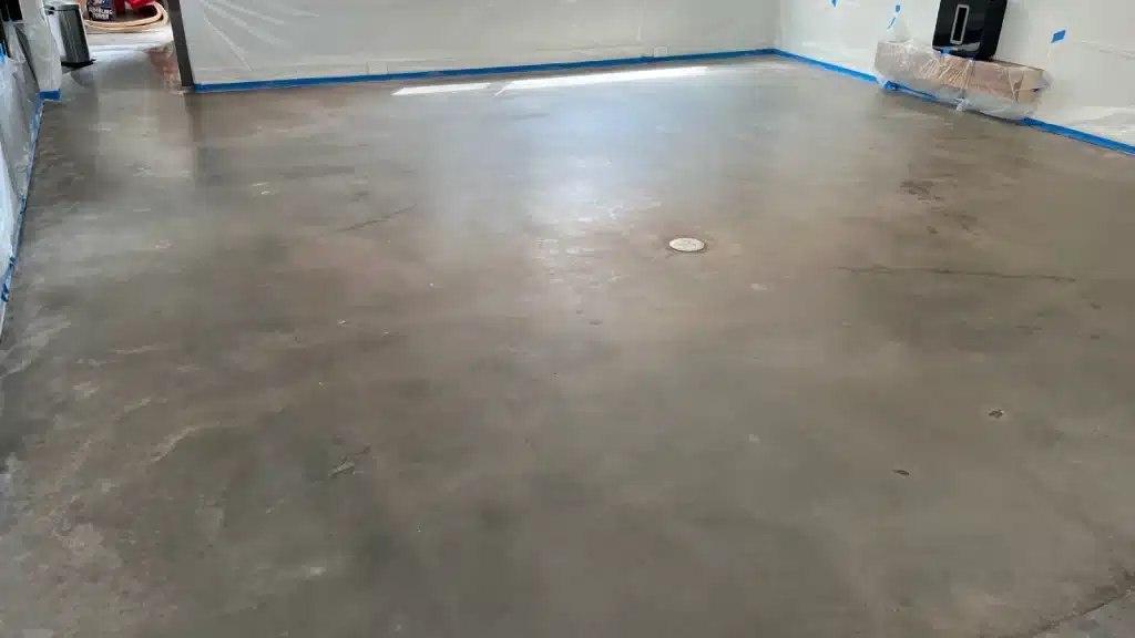 Concrete living room floor before grinding and polishing showing dull finish and surface variation.