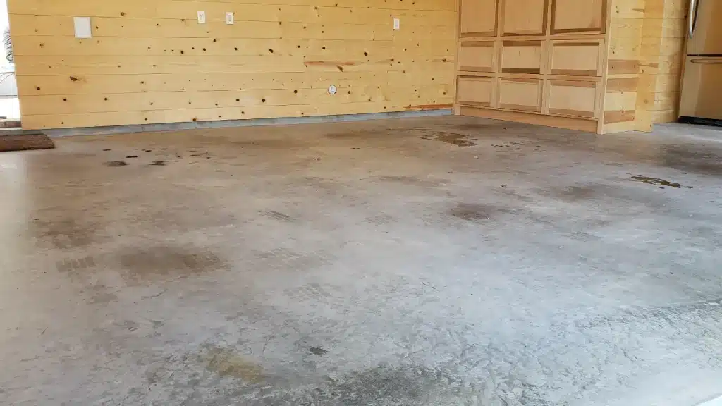Residential garage concrete floor with cracks and oil stains before epoxy coating in Houston TX