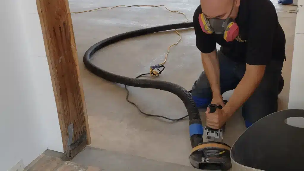 Detail edge grinding of residential garage concrete prior to epoxy coating in Houston TX