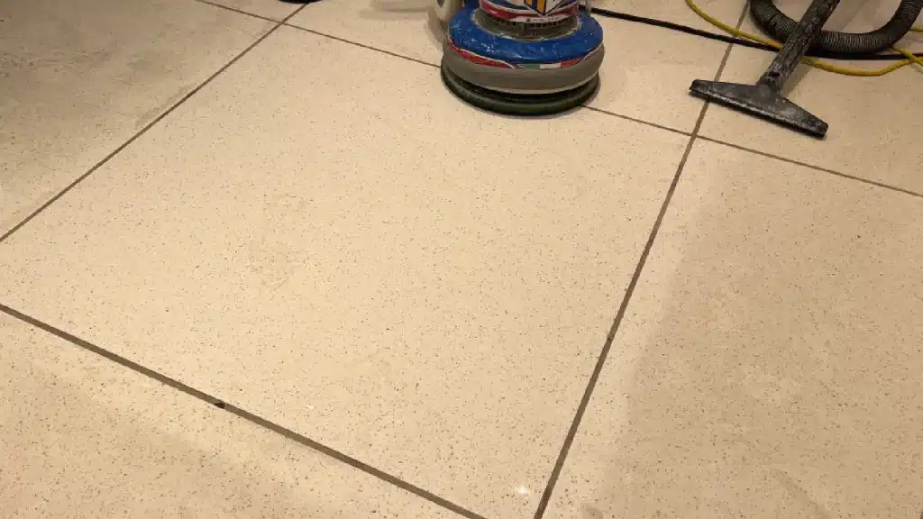 Epoxy terrazzo floor test area during restoration showing contrast between etched and refined surface.