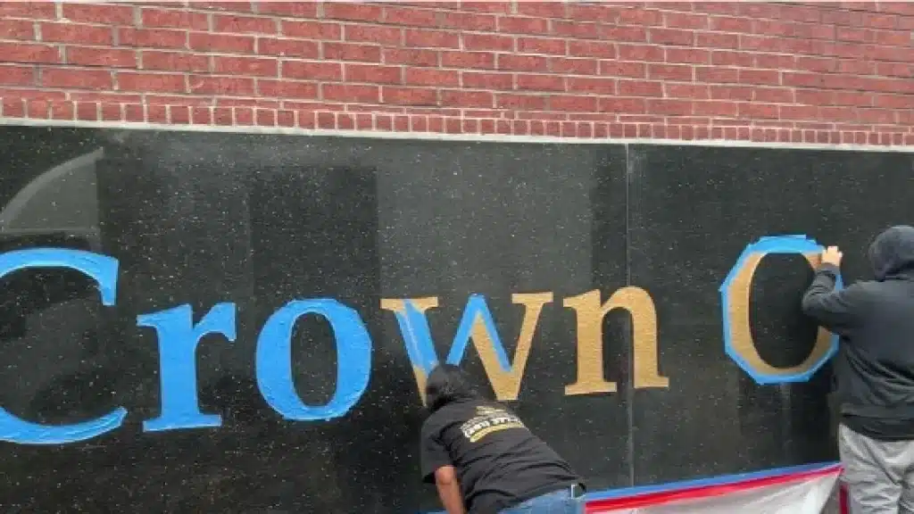 Exterior granite wall during restoration with protective masking applied prior to honing and polishing.