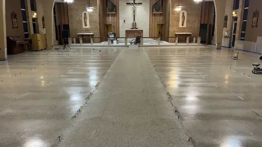 Terrazzo floor before restoration inside Immaculate Conception Church in Goliad, TX showing surface wear and dullness