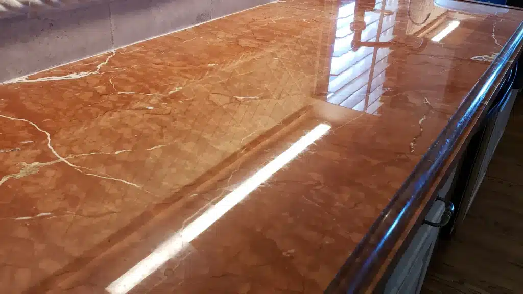 Marble kitchen countertop after restoration showing uniform polish, clean edge detail, and clear light reflection in Kemah, Texas.