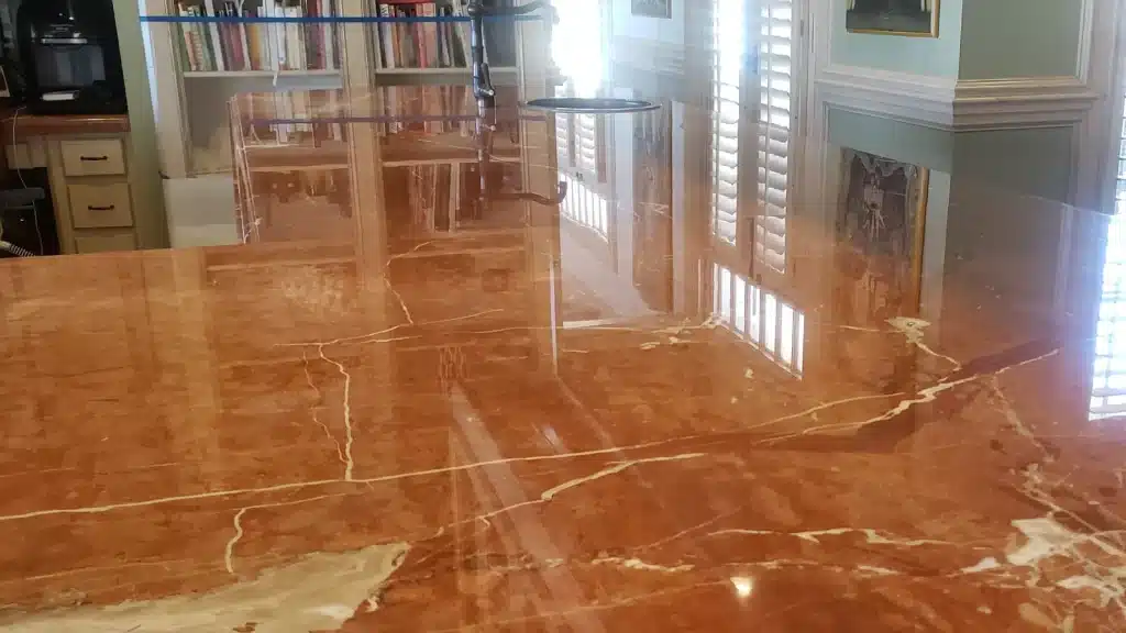 Marble kitchen island countertop after final polishing, showing improved clarity and light reflection in Kemah, Texas.