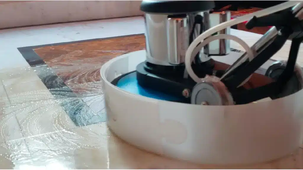 Marble floor during mechanical polishing process to restore high-gloss finish and remove traffic wear.