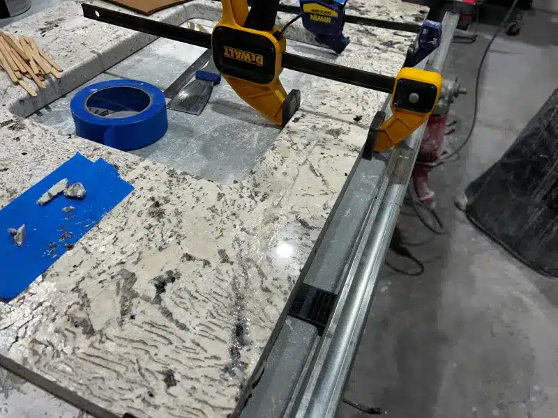 Quartzite countertop being repaired after a broken piece was reattached and restored