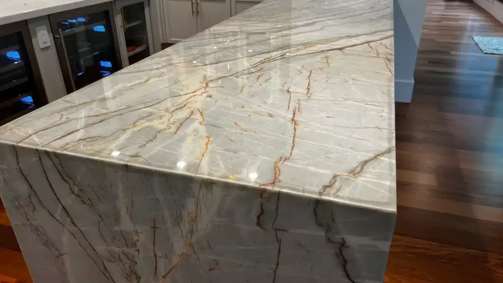 Restored quartzite kitchen island with a polished finish showing improved clarity and natural veining.