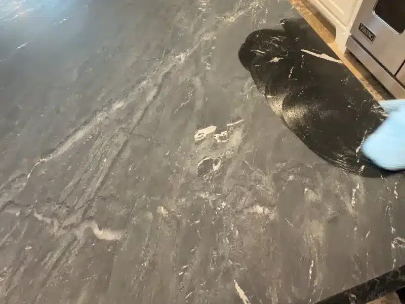 Technician applying oil to condition a soapstone countertop surface