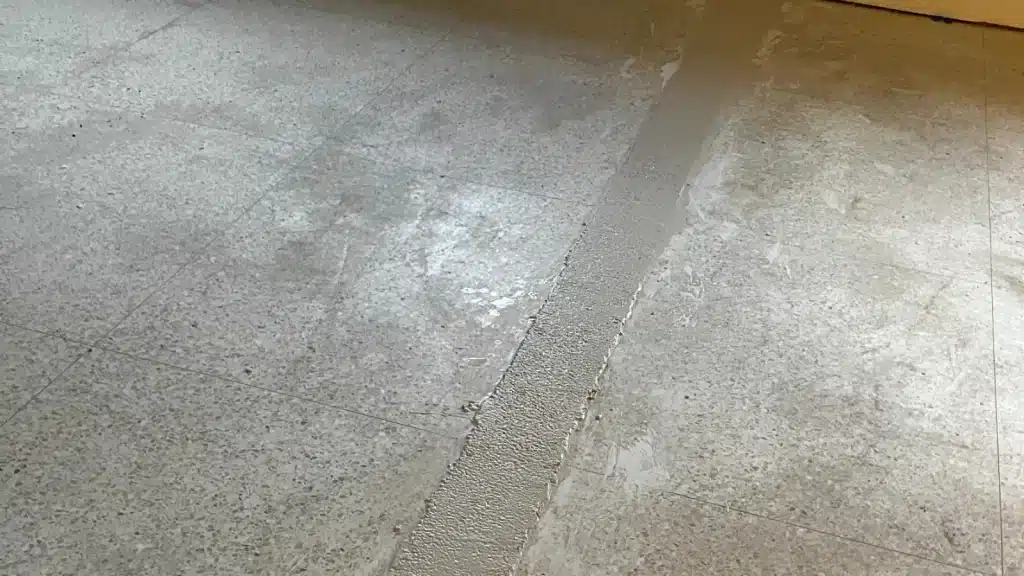 Terrazzo floor showing exposed areas before custom transition installation in Lake Jackson TX