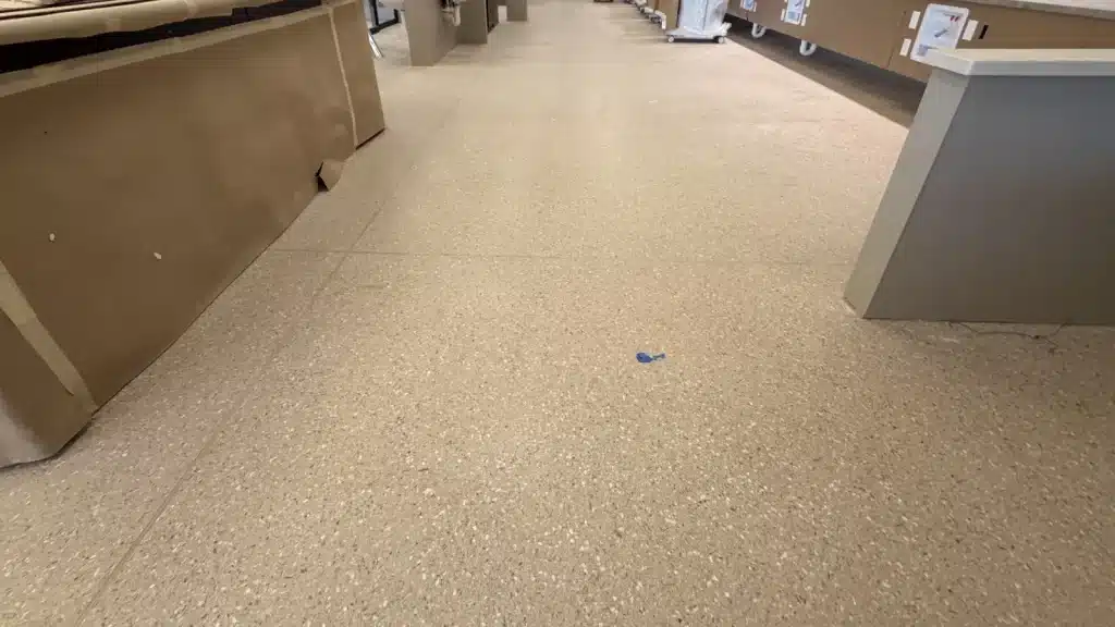 Epoxy terrazzo floor with construction haze and dull appearance before restoration in Pearland TX