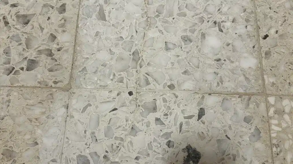 Repaired terrazzo floor crack in hallway after restoration, blended seamlessly with surrounding surface in Goliad, TX