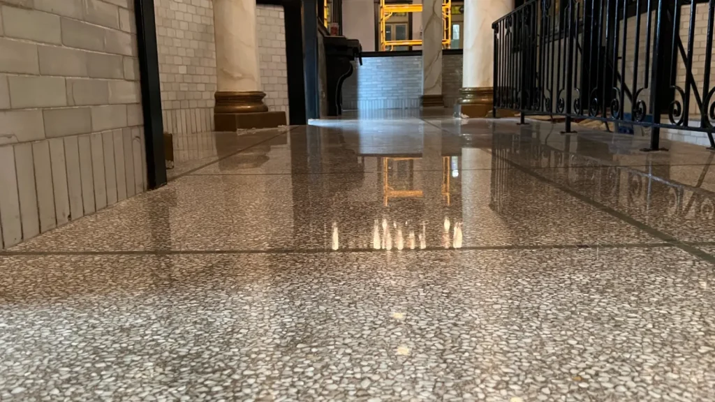 Low-angle view of restored terrazzo floor with grind marks corrected and uniform surface finish in Downtown Houston, Texas.