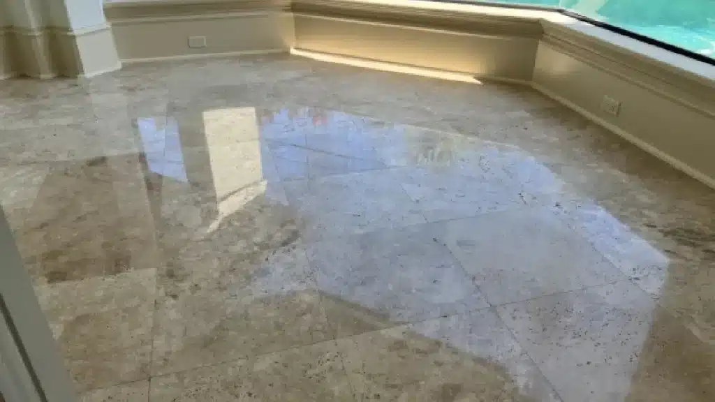 Travertine floor after polishing showing a uniform reflective finish and restored surface clarity.