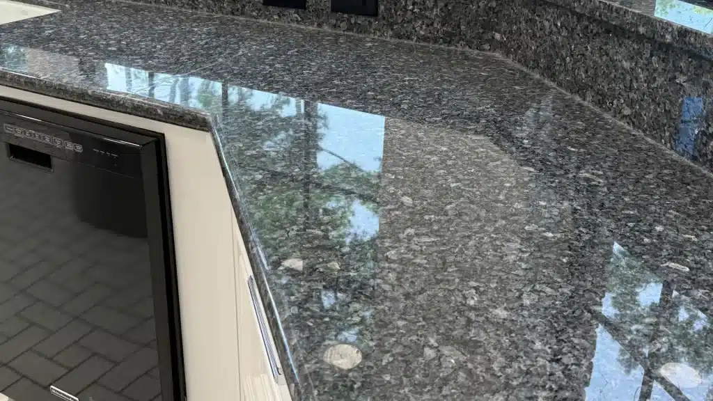 Restored polished dark granite countertop with reflective surface