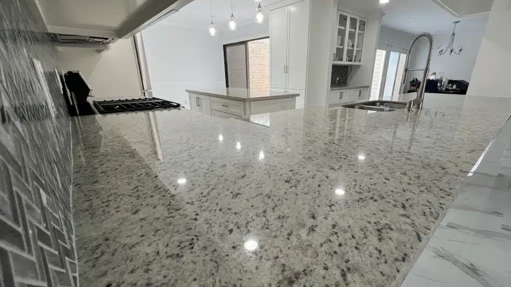 Restored light granite kitchen countertop with polished reflective surface