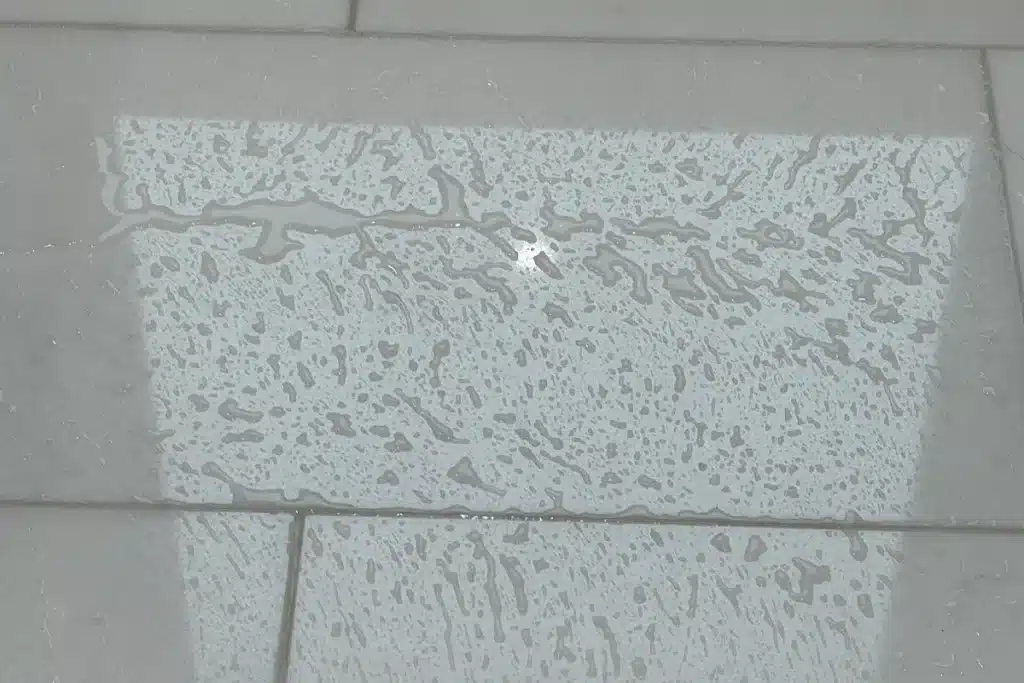 Water beading on sealed marble tile showing protective stone sealing treatment