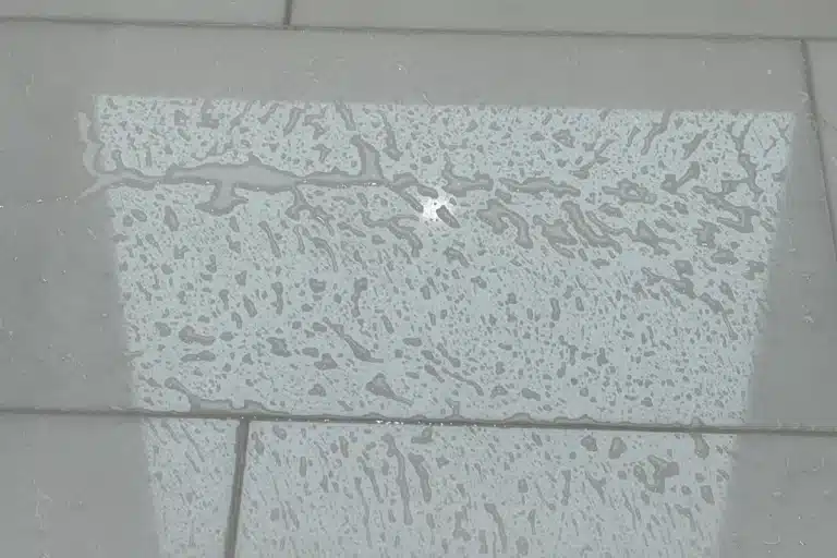 Water beading on sealed marble tile showing protective stone sealing treatment