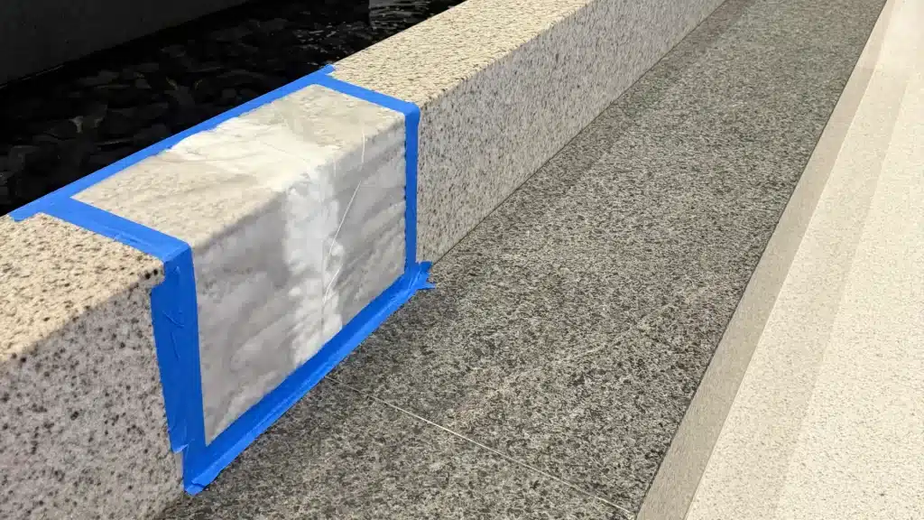 Poultice stain removal treatment applied to granite waterfall surface