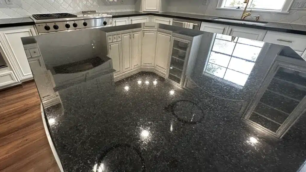 Restored black granite countertop showing polished reflection after granite restoration