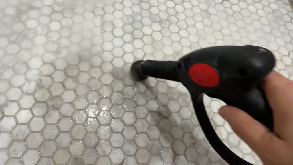 Steam cleaner being used on a natural stone hex tile floor