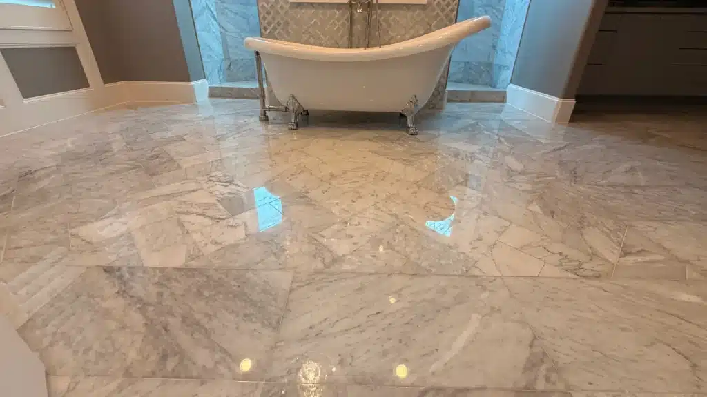 Well maintained marble bathroom floor surrounding freestanding bathtub
